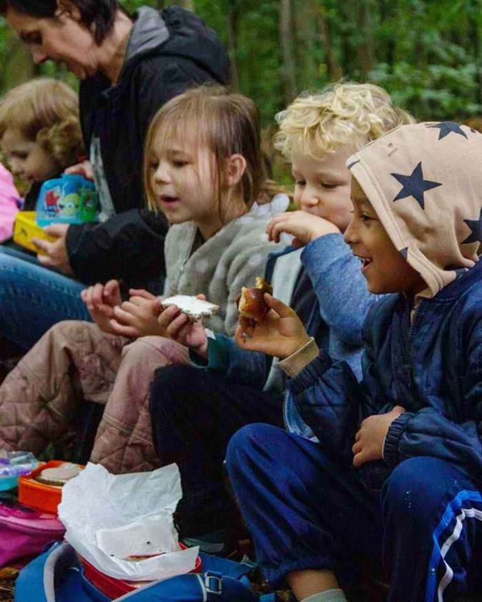 Børn spiser madpakke i skoven